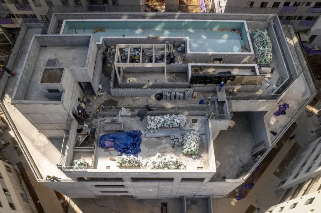 Vista aérea da cobertura com piscina e área de obras