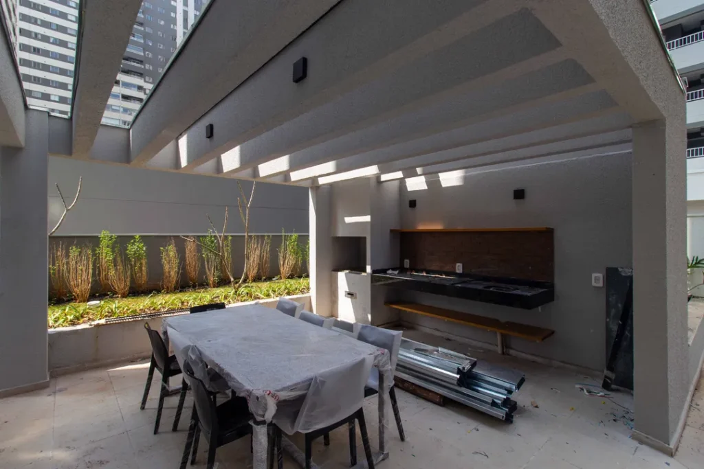 Espaço gourmet externo com mesa e churrasqueira